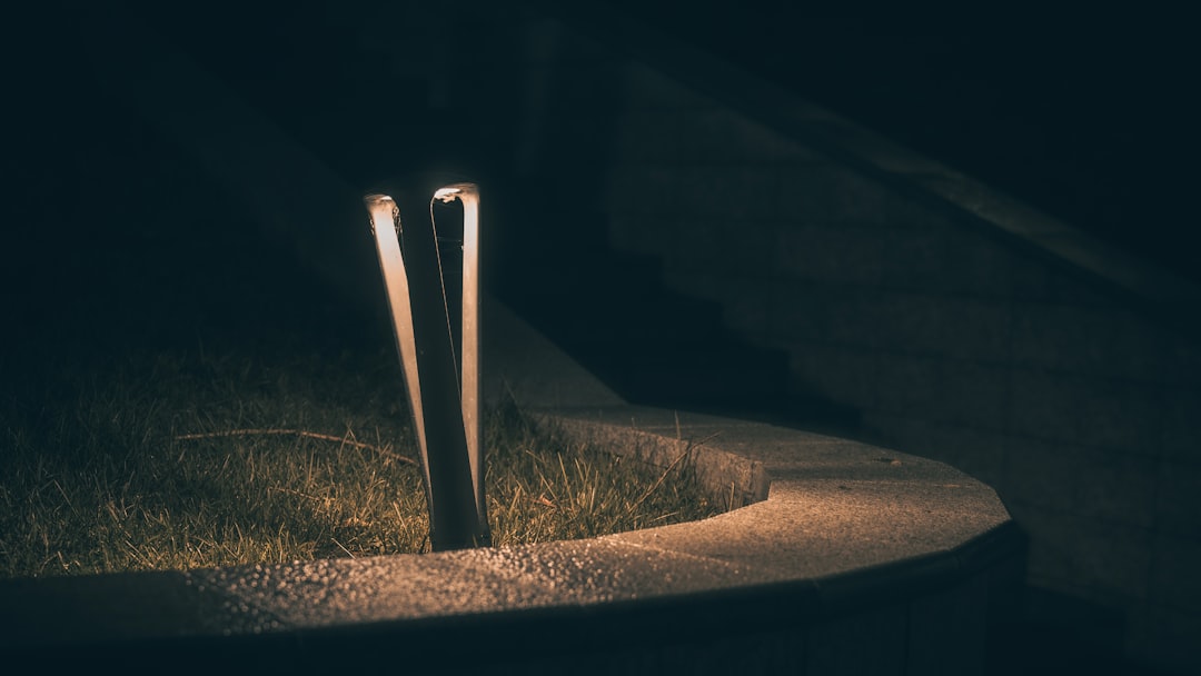 A modern outdoor lamp illuminates a path at night