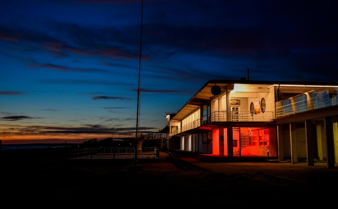 Modern building illuminated at dusk near the ocean