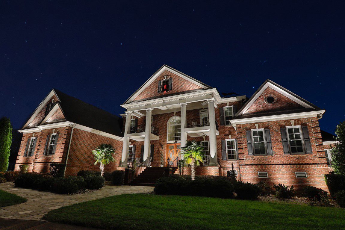 Traditional brick home with outdoor lighting