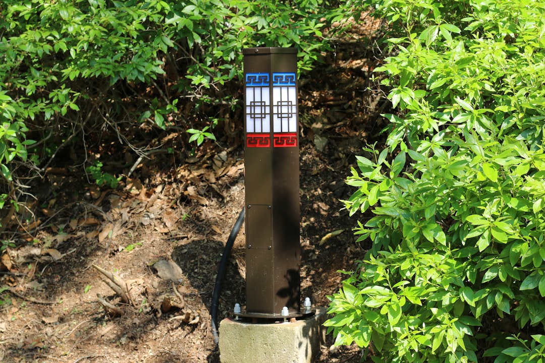 Reflective trail marker post surrounded by lush green leaves